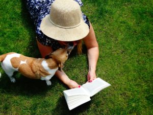 A little dog with a girl reading